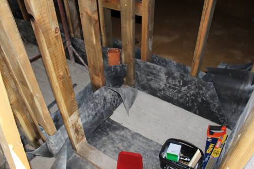 Stud walls protected from damp with plastic sheeting