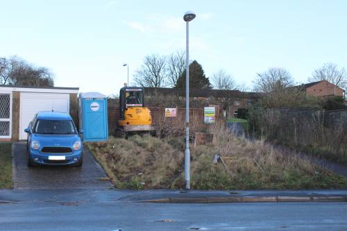 The mini-digger rolls up the front bank to start clearing the site