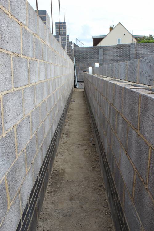 Back alley separating the house and the retaining wall