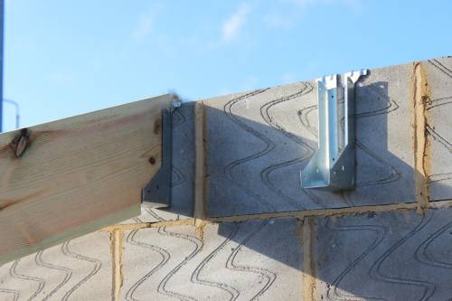 Stainless steel brackets for locating trusses against the external walls